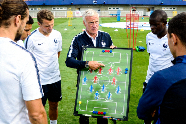 法国国家队主教练德尚在训练场上向球员讲解战术板上的阵型跑位