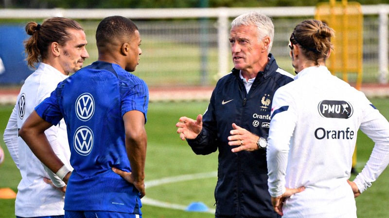 法国国家足球队在训练基地进行战术演练，主教练德尚与球员姆巴佩、格列兹曼在场边交流