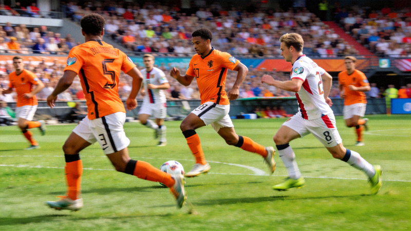 荷兰队球员在比赛中进行流畅的位置轮转，体现全攻全守现代打法的比赛场景